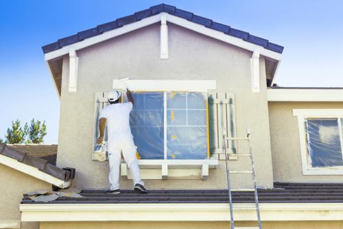 Busy House Painter Painting the Trim And Shutters of A Home.